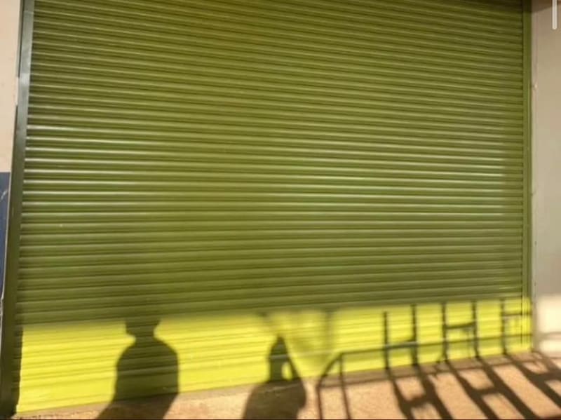Porta de enrolar pintada na cor verde em um comércio
